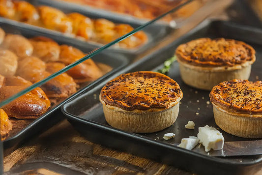 Tray of hand-crafted wholesale pies with golden, flaky pastry.