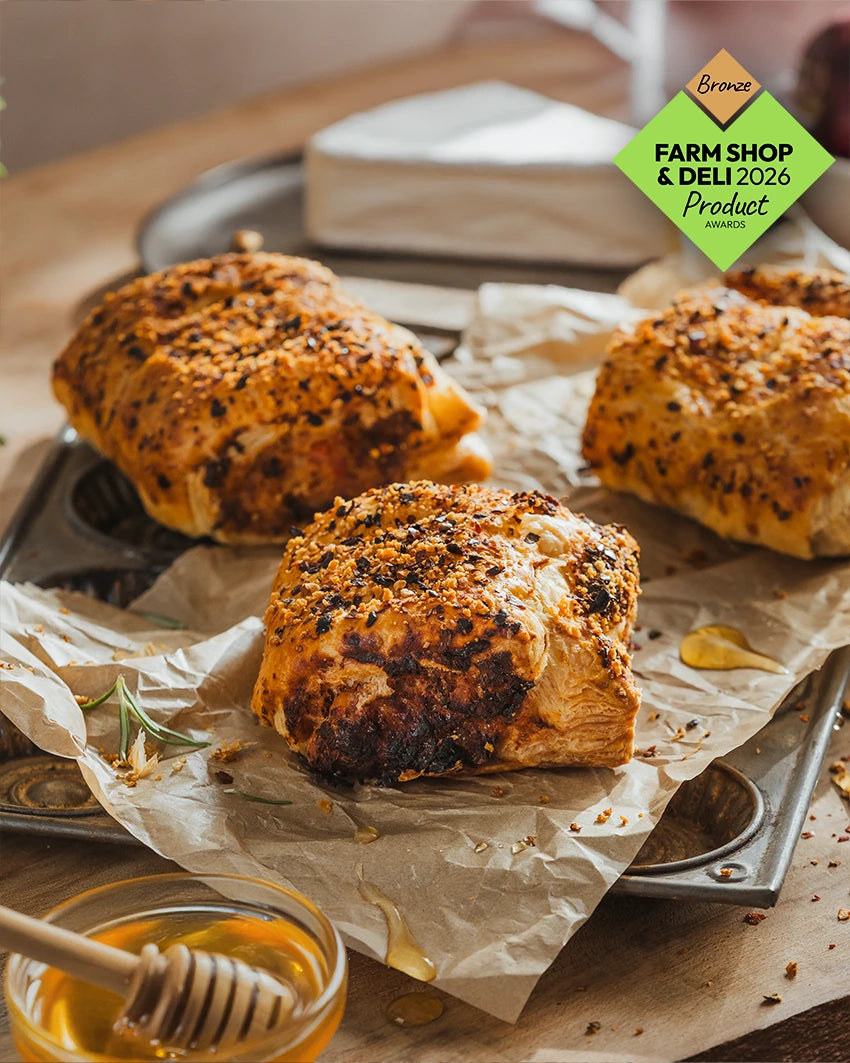 Three Hot Honey, Bacon & Brie Sausage Roll in golden puff pastry, with the bronze farm shop and deli 2026 product award
