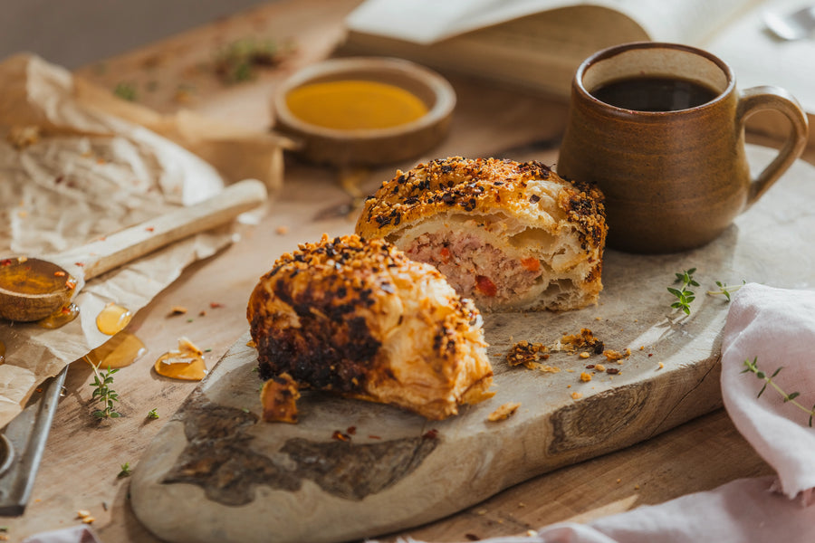 One Hot Honey, Bacon & Brie Sausage Roll cut open showing pork, bacon and brie filling