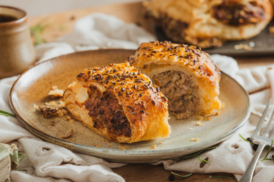 Close up of Original Gourmet Sausage Roll cut open showing pork and crackling filling.